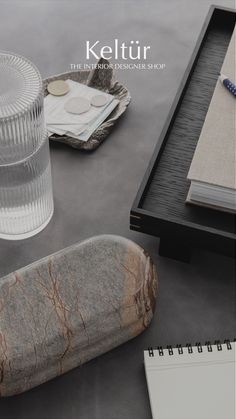 an image of a table setting with rocks and notebooks on the side, including a pen holder