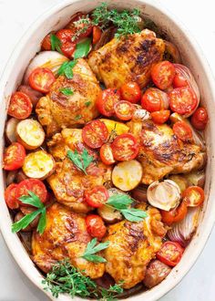 chicken with tomatoes, onions and parsley in a white bowl