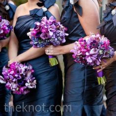 the bridesmaids are wearing black dresses with purple flowers on their bouquets,