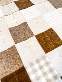 a brown and white checkered quilt on a bed