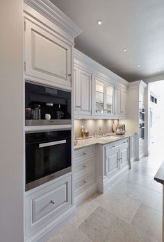 a large kitchen with white cabinets and marble counter tops is pictured in this image from the front view