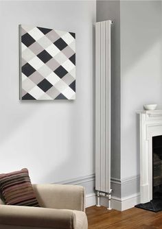 a white radiator in a living room next to a chair and fireplace with a painting on the wall