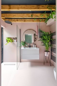 there is a bathroom with pink walls and plants