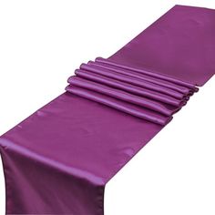 purple satin table runner with pleated edges, set on white background for use in wedding or party decor