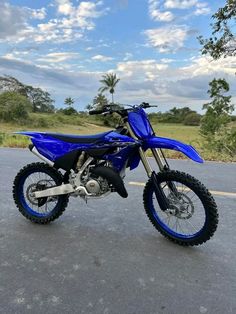 a blue dirt bike is parked on the street