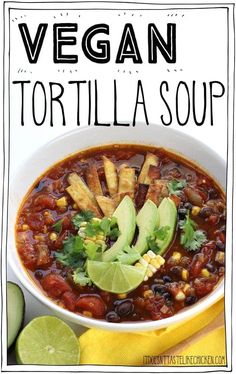 vegan tortilla soup in a white bowl with avocado and cilantro