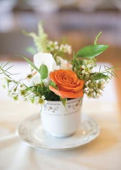 an arrangement of flowers in a cup on a table