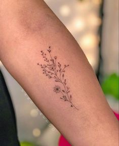 a woman's arm with a small flower tattoo on the left side of her body