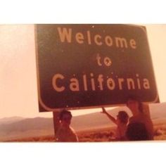 three people holding up a welcome to california sign