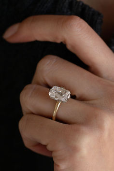 a woman's hand holding a diamond ring