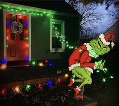 a christmas light display in front of a house with lights on the door and an image of person dressed as santa clause