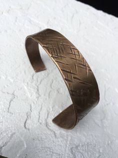 "This cuff bracelet is hand forged from solid bronze and has been textured with an organic cross hatched pattern. Bronze is a lovely metal and compliments any skin tone with its warm, rich hue. Bronze is the traditional gift for the 8th Anniversary. MEASUREMENTS & SPECIFICS: SIZE: ID is 2.5\" - cuffs are adjustable (one size fits most) Request a custom order for smaller or larger wrists WIDTH: tapers from approximately 1\" to .5\" METAL: Solid bronze 88/12 copper and tin FINISH: Choose from Adjustable Hand Forged Bronze Bracelets, Hand Forged Bronze Metal Cuff Bracelet, Bronze Hand Forged Metal Cuff Bracelet, Adjustable Hand Forged Bronze Cuff Bracelet, Adjustable Hammered Bronze Bracelets, Adjustable Etched Brass Cuff Bracelet, Adjustable Brass Etched Cuff Bracelet, Adjustable Hand Cast Bronze Bracelets, Rustic Adjustable Etched Jewelry