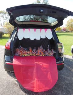 the back end of a car with an open trunk filled with candy bar monster teeth