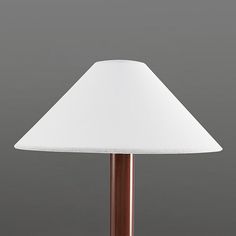 a table lamp with a white shade on the base and a brown wooden pole underneath it