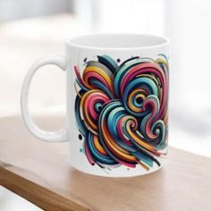 a colorful coffee mug sitting on top of a wooden table