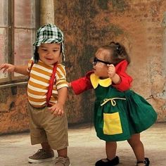 two small children dressed in costumes standing next to each other