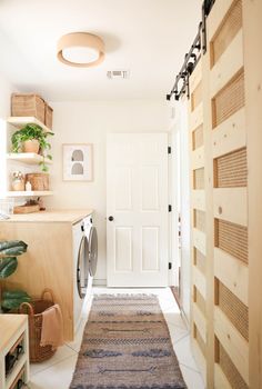 a washer and dryer in a room with wooden shelves on either side of the door