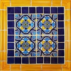 a blue and yellow tile with flowers on it