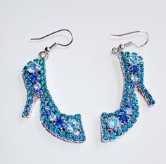 "New, Never Worn Lunch At The Ritz \"The Blues\" High Heel Earrings. Flashy,shimmering, Swarovski crystals in various shades of blues compose these showy silvertone high heel earrings. Turquoise, powder blue, and navy crystals radiate in the sunshine! Measure 2 1/2\"L X 1\"W. Secured with a french hook. Signed Lunch At The Ritz on backside. Mint condition." Blue Jeweled Crystal Earrings For Party, Blue Crystal Earrings With Sparkling Stones For Party, Evening Blue Crystal Earrings With Rhinestones, Blue Rhinestone Earrings For Evening, Blue Crystal Embellished Jewelry For Gift, Blue Crystal Embellished Jewelry Gift, Blue Jeweled Crystal Earrings, Blue Dangle Earrings With Rhinestones, Nickel-free Light Blue Earrings For Party