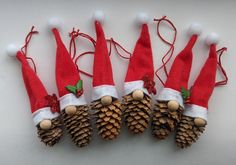 four pine cones with santa hats on them