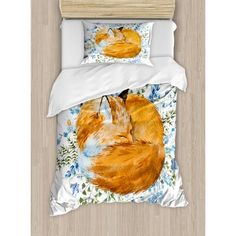 an orange fox sleeping on top of a blue flowered bedding with white sheets