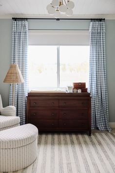 a baby's room with blue and white curtains