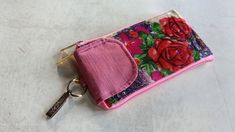 a pink purse with flowers on it and a keychain