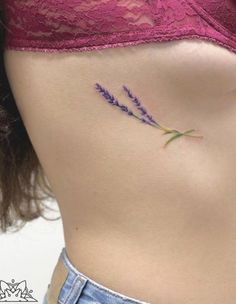 a close up of a woman's stomach with lavender flowers on her left side