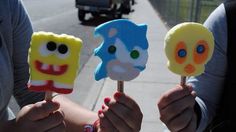 three people holding marshmallows with faces on them