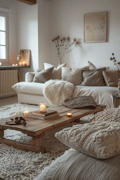 a living room filled with lots of furniture and candles on the coffee table in front of it