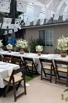 an outdoor dining area with tables and chairs set up for a party or celebration,