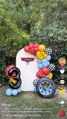 balloons are attached to the back of a car in front of some bushes and trees