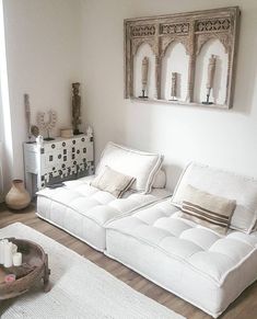 a white couch sitting on top of a hard wood floor next to a wooden table