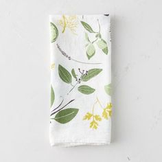 a white napkin with green and yellow leaves on it, sitting on top of a table