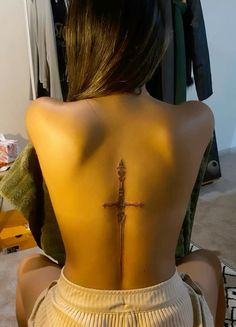 a woman with a cross tattoo on her back