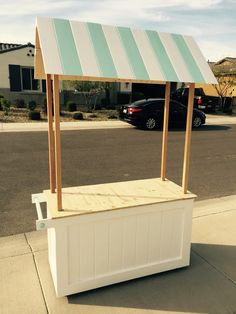 a white and green striped awning on the side of a street