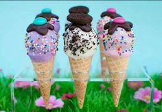 three ice cream cones with chocolate and sprinkles on them sitting in the grass