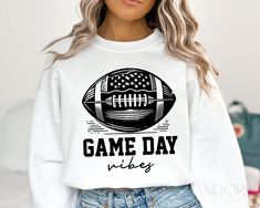 a woman wearing a white sweatshirt that says game day vibes with an american flag on it