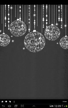 a black and white photo with christmas ornaments hanging from it's sides, in front of a dark background