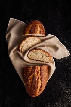 two loaves of bread sitting on top of a cloth