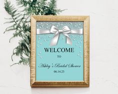 a welcome sign hanging from the side of a wooden frame next to a potted plant