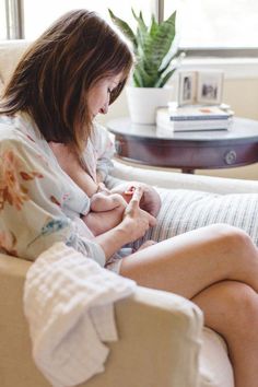 a woman sitting in a chair holding a baby