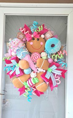 a wreath made to look like a teddy bear with lots of decorations on it's front door