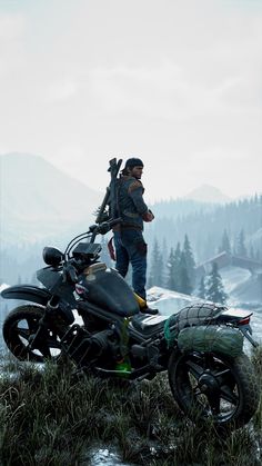 a man standing next to a motorcycle on top of a grass covered hill with trees in the background