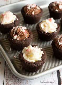 chocolate cupcakes with white frosting and sprinkles on a tray