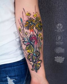 a woman's arm with flowers and leaves tattoo on the left side of her arm