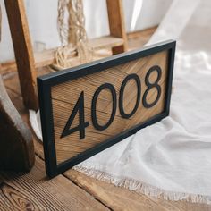 a house number sign sitting on top of a wooden floor