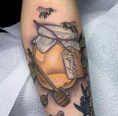 a tattoo with a honey jar and bees on it