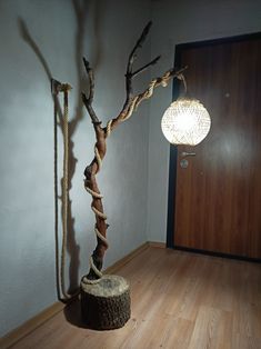 a tree that is sitting in the middle of a room next to a light fixture