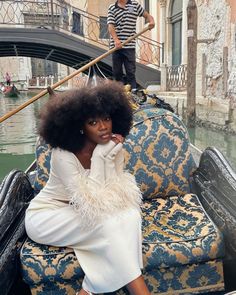 a woman sitting on the back of a gondola